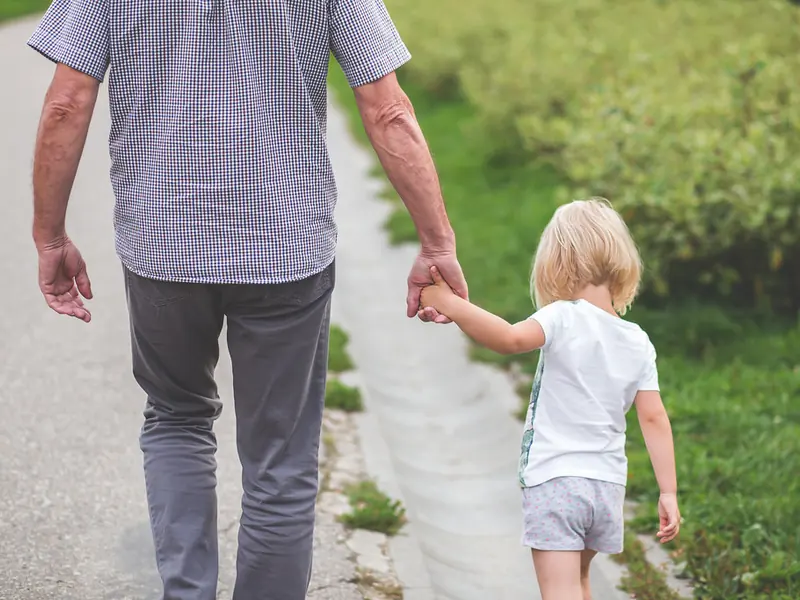 An adult and child walking together
